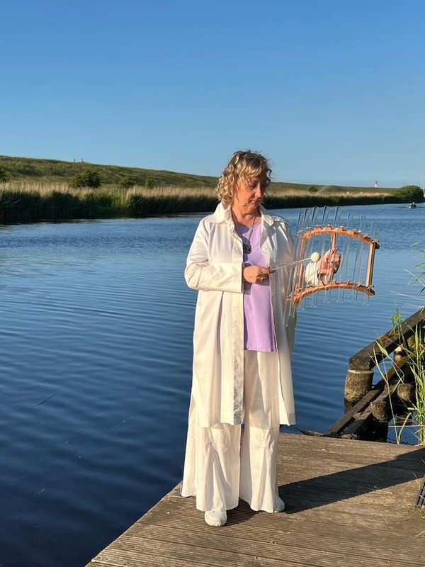 Naria am Wasser mit ihrem Klanginstrument